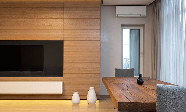 Klimaanlage: Wandgerät hängt in einem Wohnzimmer an der Zimmerwand