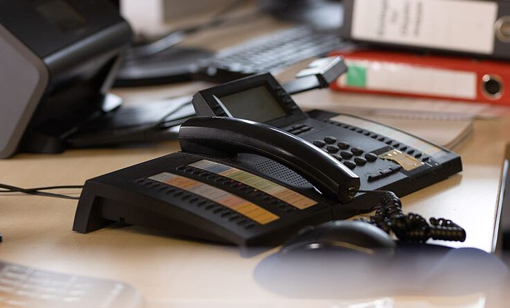 Telefongerät steht auf einem Büro-Tisch