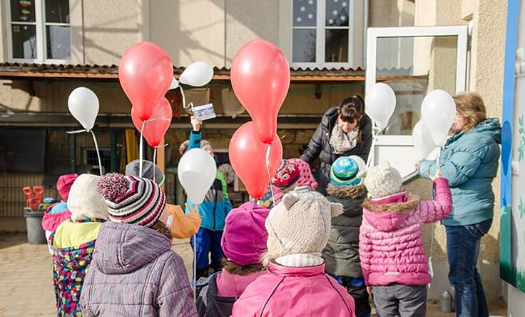 Kindergartenkinder spielen mit Luftballons
