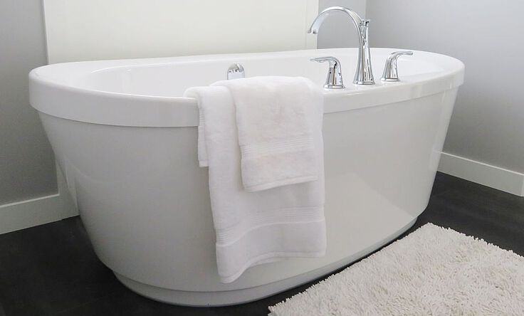 Schrägansicht einer freistehenden, weißen Badewanne in einem Badezimmer